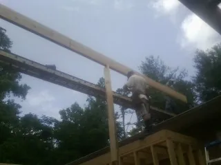 Carpenter setting a ridge beam over a new addition frame — Ice Dam Removal by Roofing Brothers in Jenkintown