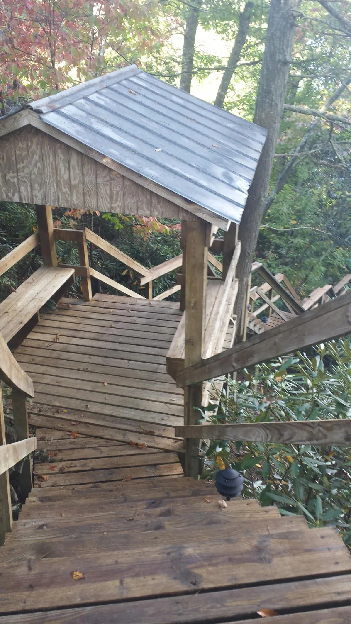 Metal roofed shelter over wooden steps on a wooded walkway — Skylight Repair & Installation work by our crew in Jenkintown